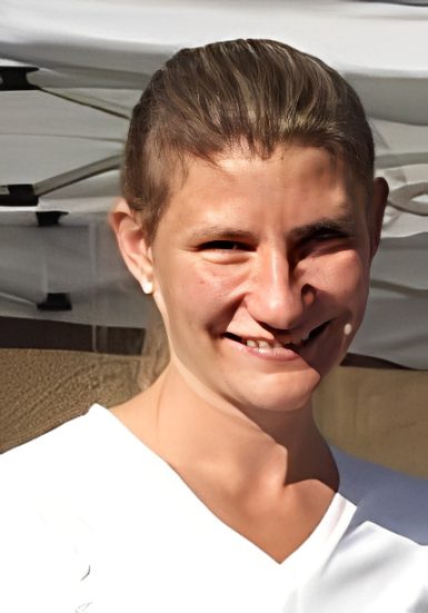 Smiling woman in white shirt outdoors